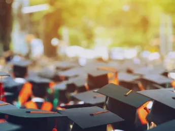 Photograph of students in caps and gowns graduating from college
