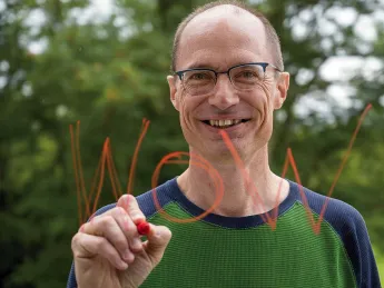 Mark Saltveit writes "Wow" on a piece of glass
