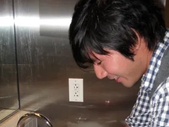 A student using a "Tapminder" device in the men's bathroom
