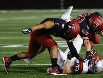 Tag team: Harvard senior captain and defensive back Wes Ogsbury Jr. (1) and senior linebacker Joey Goodman (59) doubled up on Brown end Dan Gemmell.