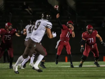 Charlie Dean throws a football across field.