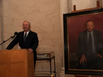 Lawrence H. Summers at the lectern next to his official portrait