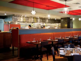 Evoo’s earthy food is served in a modern, open interior with a view of the kitchen.