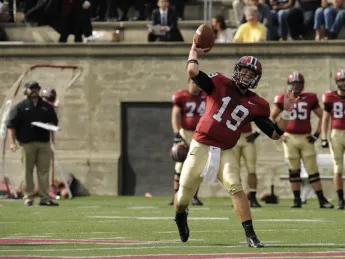 Harvard's Colton Chapple throws a football to an out-of-frame receiver.