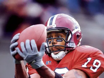A Harvard player catches a ball at eye level.