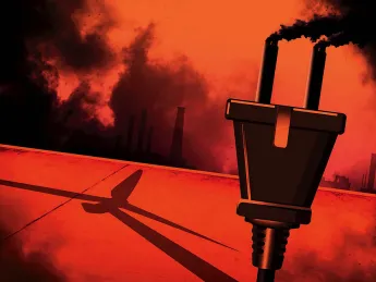 A smokestack spewing smoke with a wind turbine in its shadow