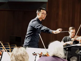 Sam Wu conducts an orchestra