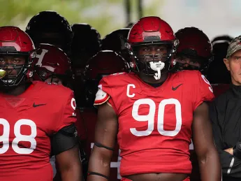 Senior defensive lineman David Madzivanyika, captain and defensive lineman Truman Jones, and coach Tim Murphy get ready to lead the team out of the tunnel before kickoff.