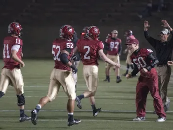 A welcoming committee greeted place-kicker Andrew Flesher after his game-winning field goal in the final minute of the Dartmouth game. Left to right: backup quarterback Michael Pruneau (11), the holder on the kick; team captain Josh Boyd (52); Flesher (2); injured tight end Cameron Brate (87); injured linebacker Connor Sheehan (50); and special teams coach Ryan Crawford.
