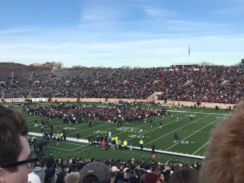 A large group of protestors standing on a football field.