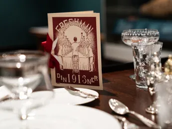 A table with a fancy menu and table settings.