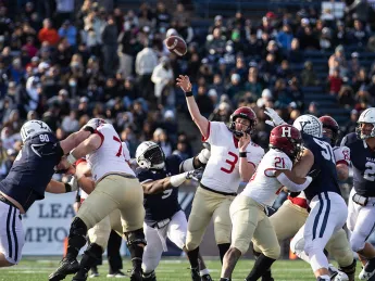 Luke Emge throws the football amidst Yale defenderss
