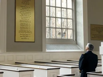 In Memorial Church, General George W. Casey Jr. views the plaque commemorating the Harvard dead of the Vietnam War, among them his father, George W. Casey ’45.