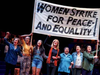 Scene from "Gloria, A Life," showing women marching in solidarity with protest sign