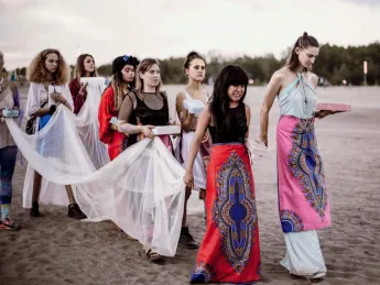 A procession of women heading toward a lake