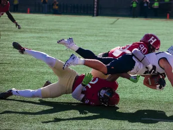  Harvard’s Truman Jones (90) and Khalil Dawsey corral Yale running back Joshua Pitsenberger. 