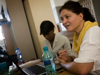 Lecturer on medicine Krista Dong directs iTEACH, a set of innovative initiatives to improve HIV care in South Africa. In the background is iTEACH deputy director Zinhle Thabethe.