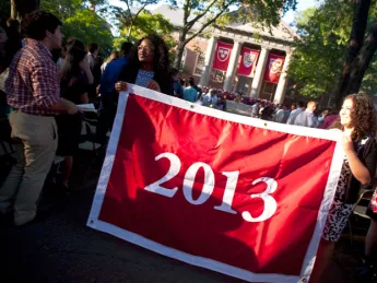 Seniors Kia J. McLeod (left) and Andrea R. Flores, vice president and president of the Undergraduate Council, display the banner that they presented to the class of 2013.