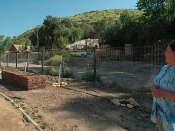 Ana Lamilla surveys the Renca development from the still-under-construction park on a ridge above. Behind her, part of the squatter settlement where she once lived remains.