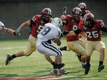 HOT PURSUIT: Defenders Schultz (52), Curtis (91), and Barnes (25) closing in on Yale back Mike McLeod.
