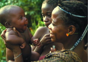 In the Ituri Forest of the Congo, Efe Pygmy women collect a saliva sample from an infant for medical analysis.