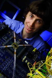 Julie Fouquet with her ground-breaking all-optical switchÑthe diamond-shaped object in the center of the circuit board where the cables meet. 