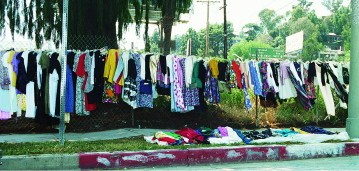 Sidewalk sale clothing hung out not to dry but 