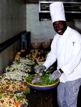 Vincent James doles out the greens for alumni spreads inside a refrigerated truck. 