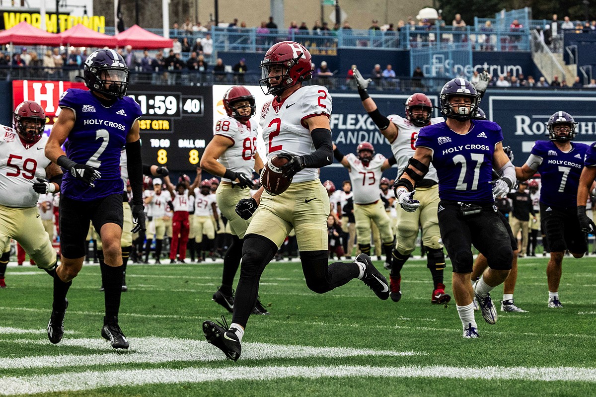 Harvard player running with ball into end zone