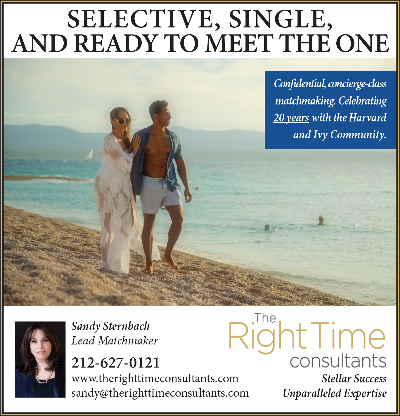 A couple walks along a sandy beach, smiling, with the ocean in the background.