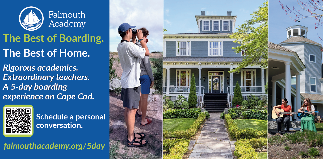 Two students taking photos in front of a stylish coastal house with lush greenery.