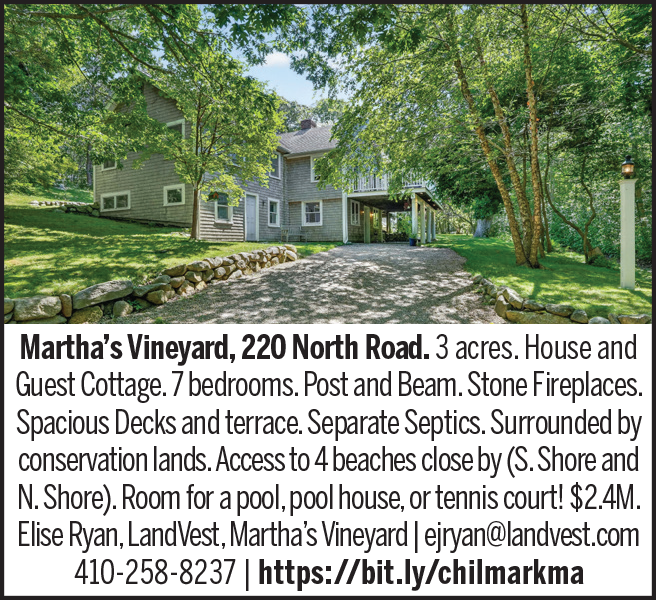 A spacious house surrounded by trees, featuring a driveway and a guest cottage.