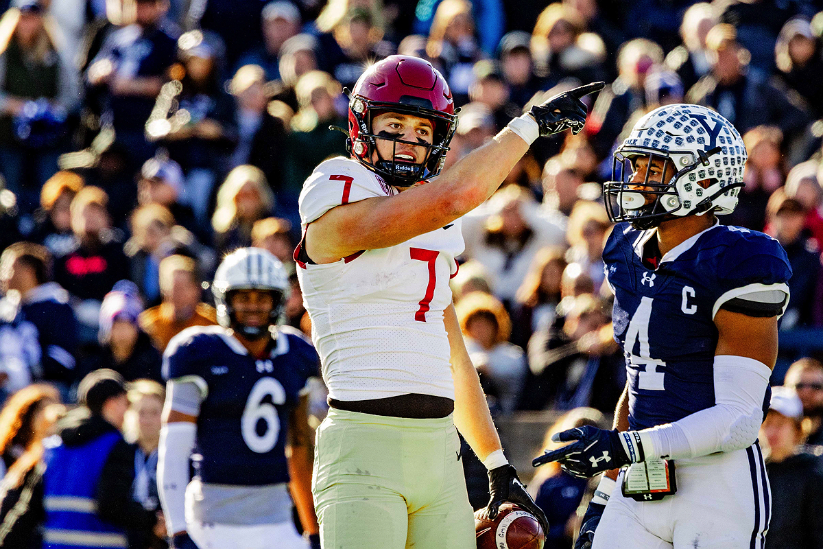 Harvard player signals after catch with Yale player standing next to him