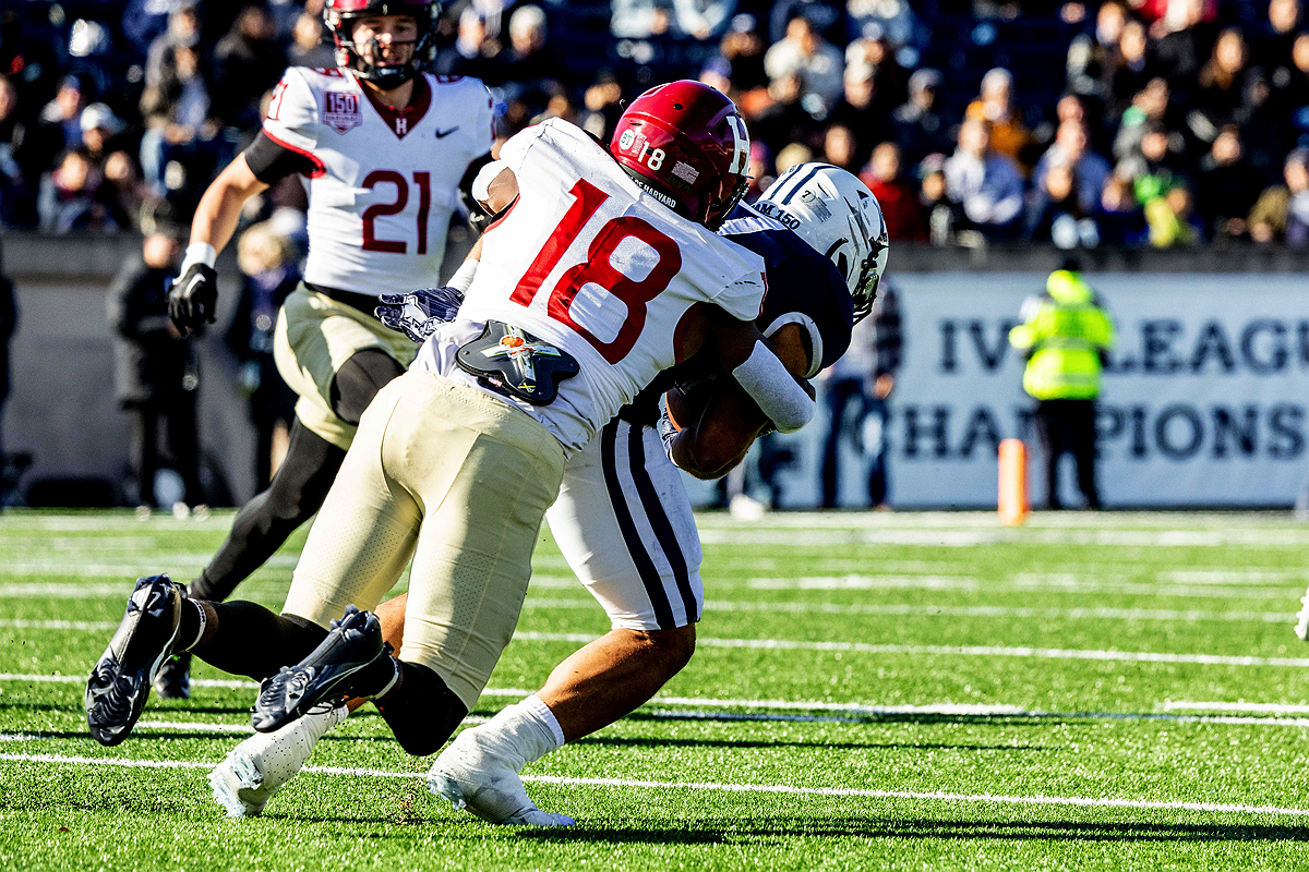 Harvard player tackles Yale player who has the ball