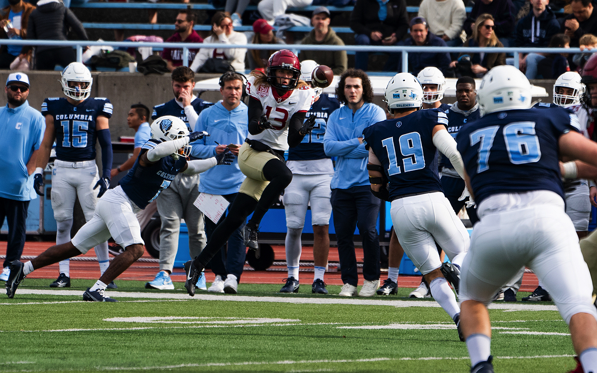 Harvard player attempts to catch ball with Columbia players in pursuit