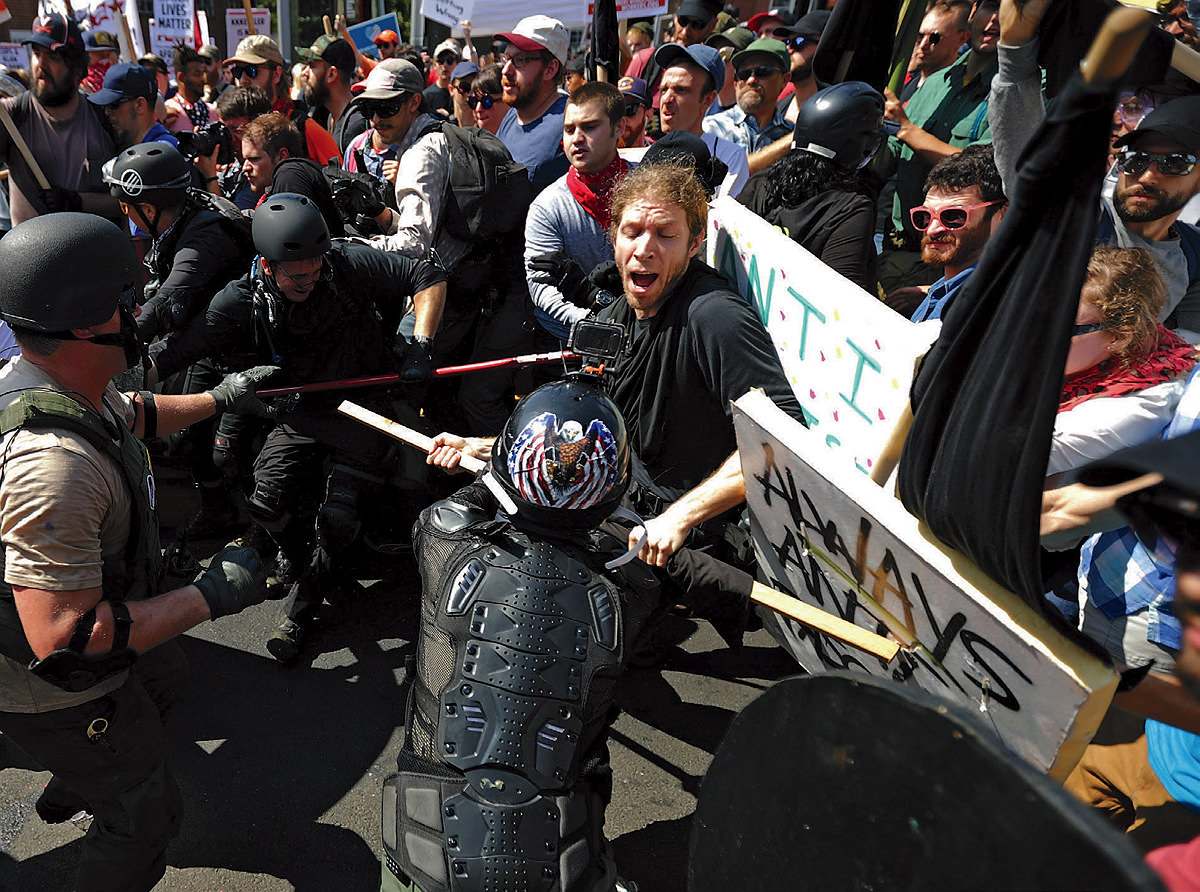 Counterprotesters clash in the street with white nationalists and "alt-right" members carrying sticks and dressed in helmets and militia gear 