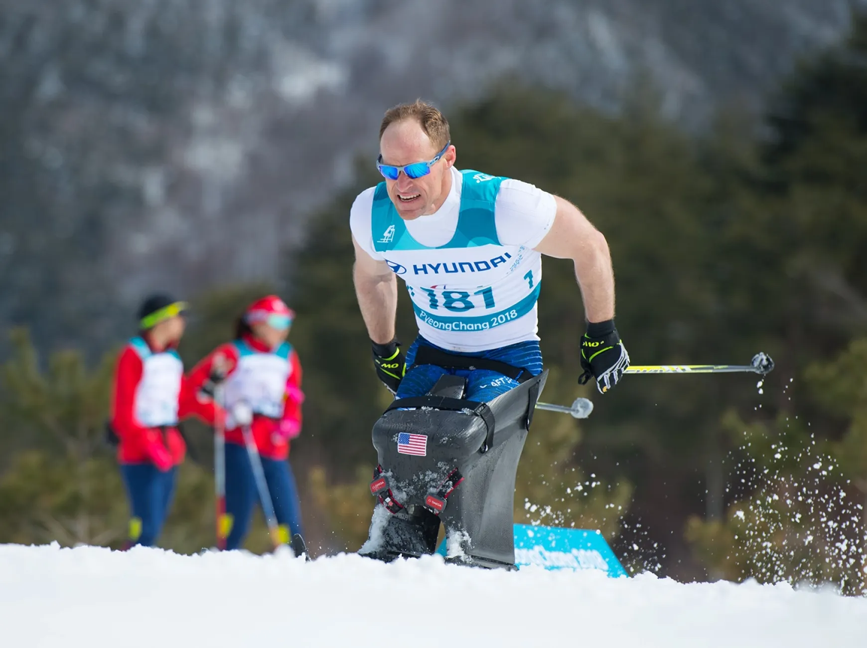 Paralympic skier Dan Cnossen on the course wearing glasses and holding his poles 