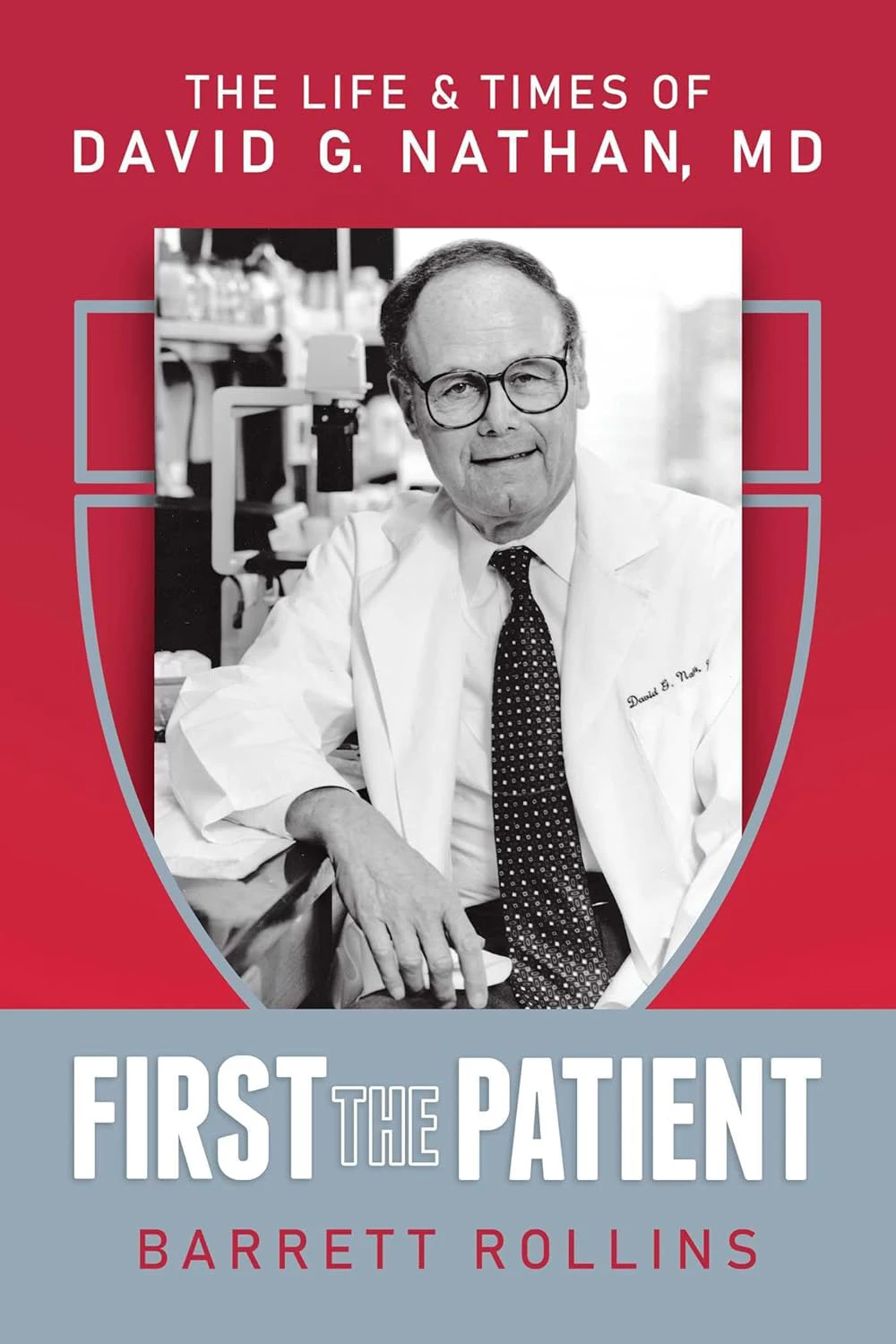 Book cover for "First The Patient: The Life and Times of David G. Nathan" by Barrett Rollins, with a black and white photograph of  David G. Nathan over the Harvard crest