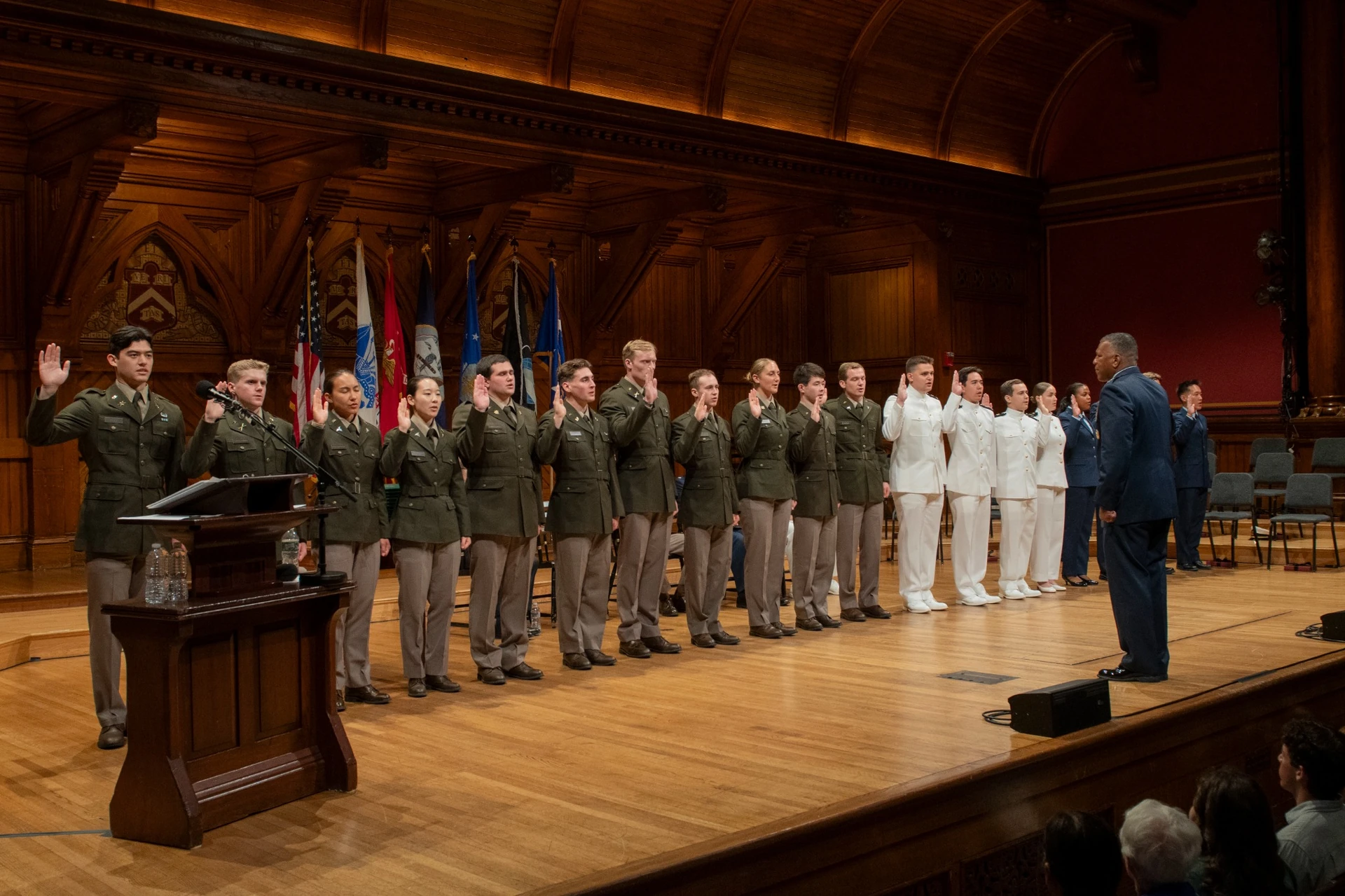 Male and female cadets line the stage to be sworn in by Lieutenant General Richard Clark