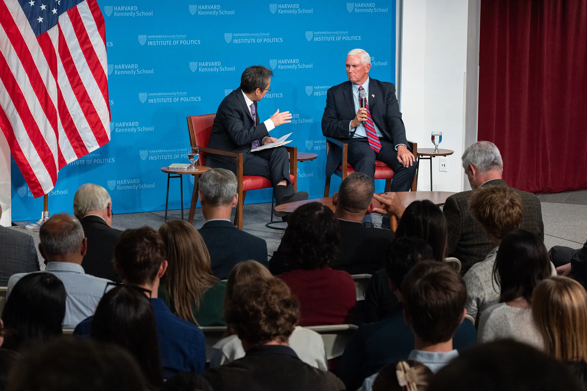 Mike Pence speaks at a Kennedy School panel with a moderator and audience in the foreground