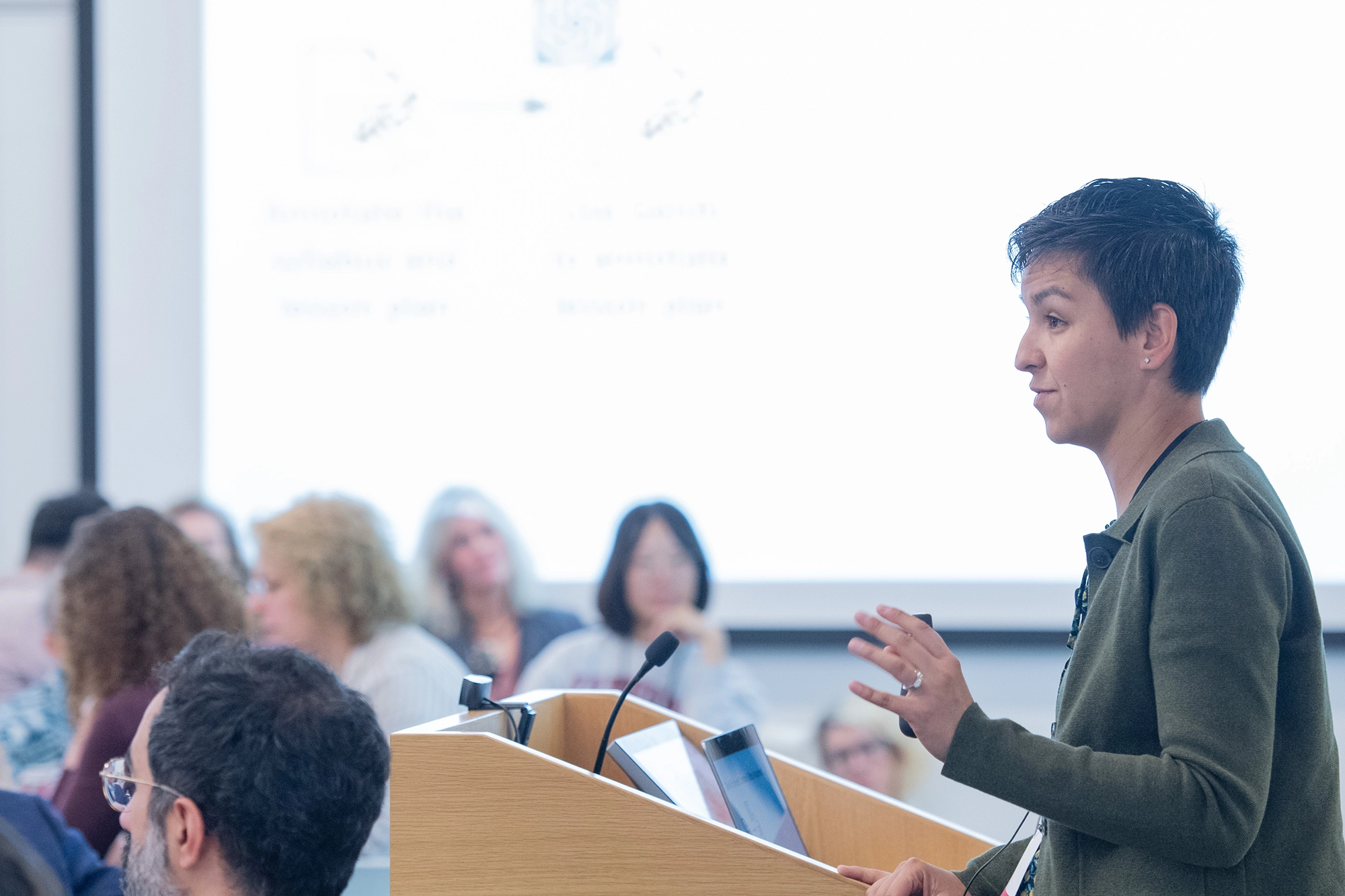 Tari Tan at a podium with an audience in a foreground