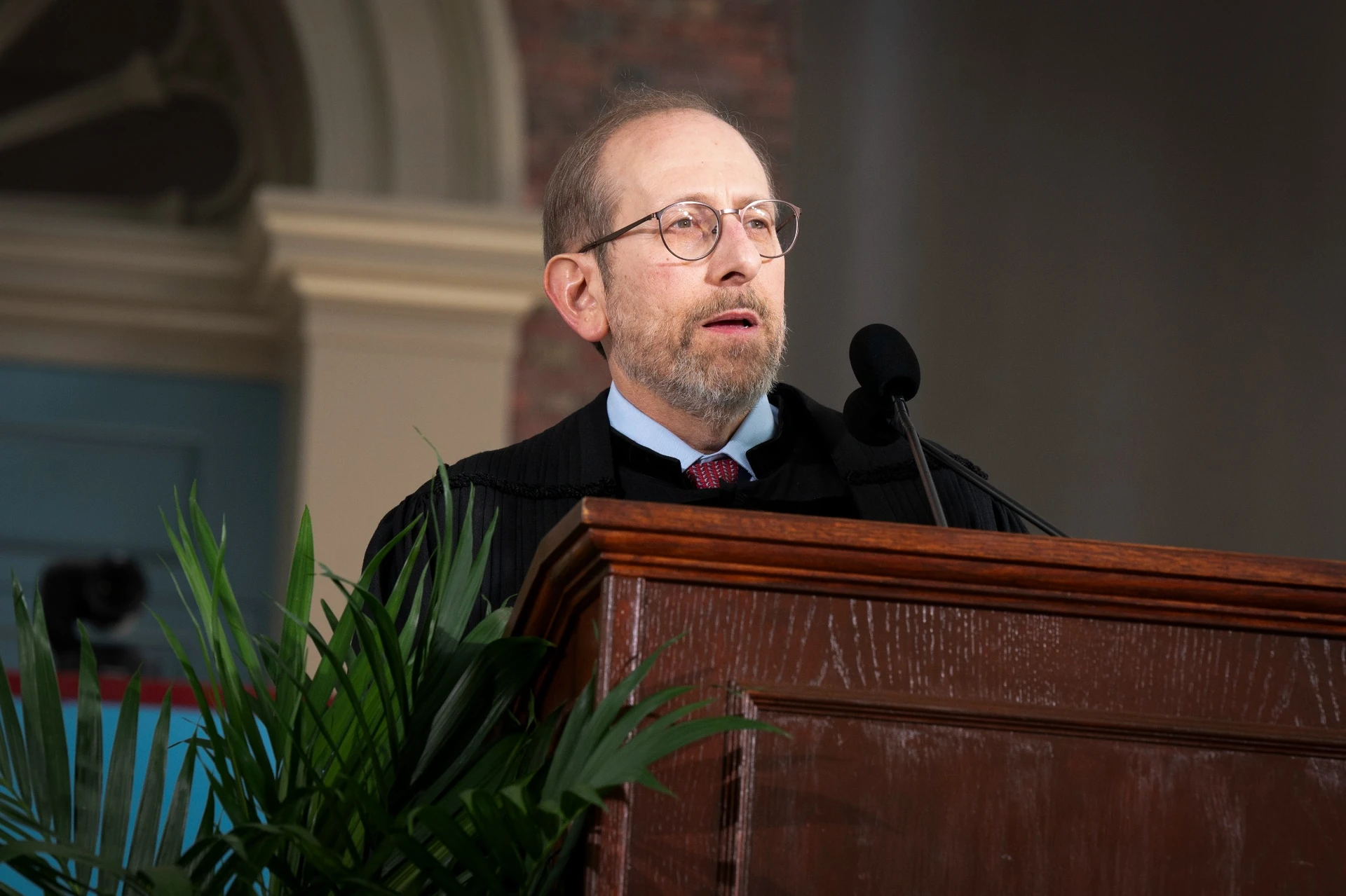 Alan Garber wearing black robe speaks at podium