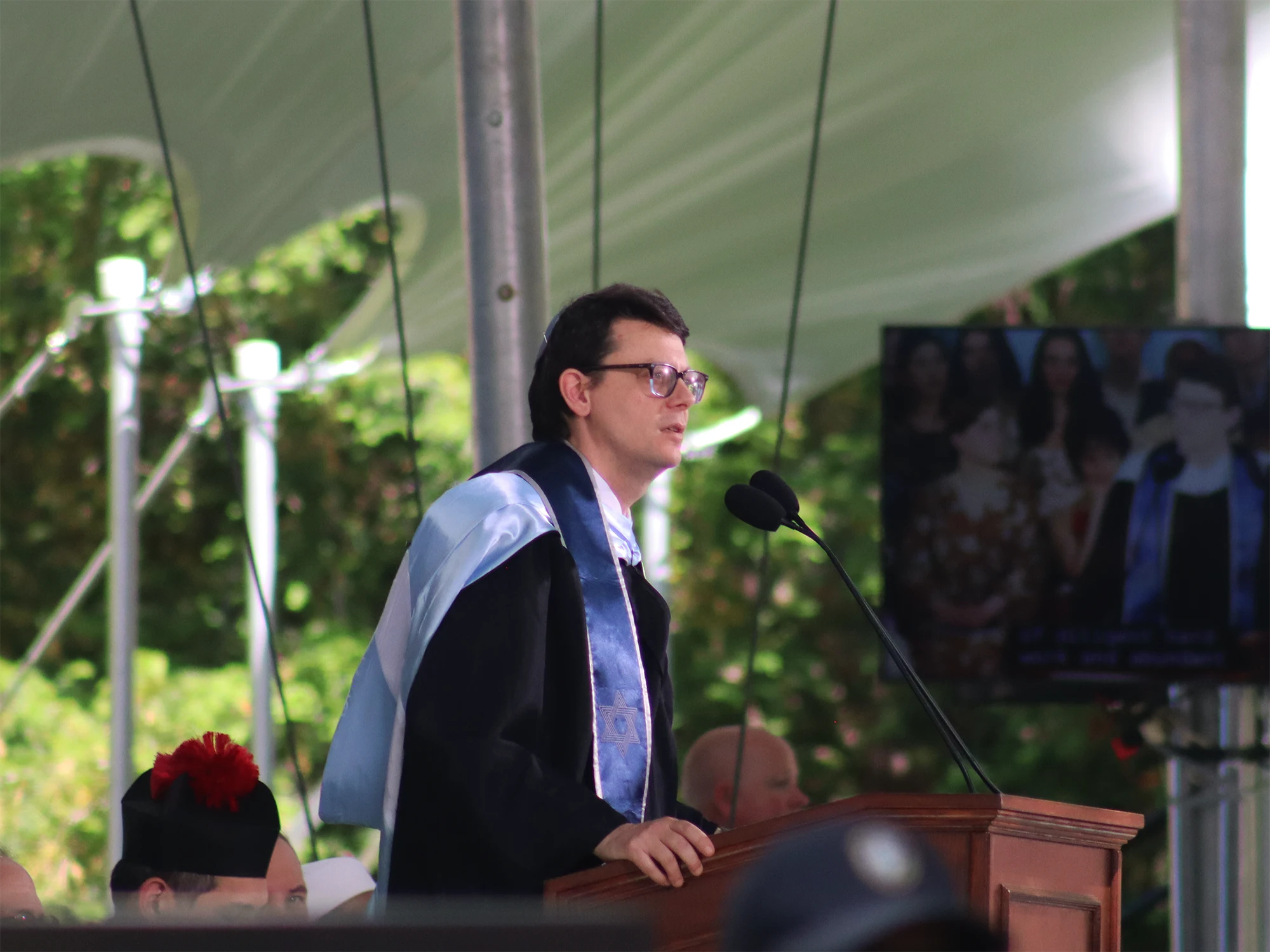 Rabbi Jason Rubenstein speaks at the podium