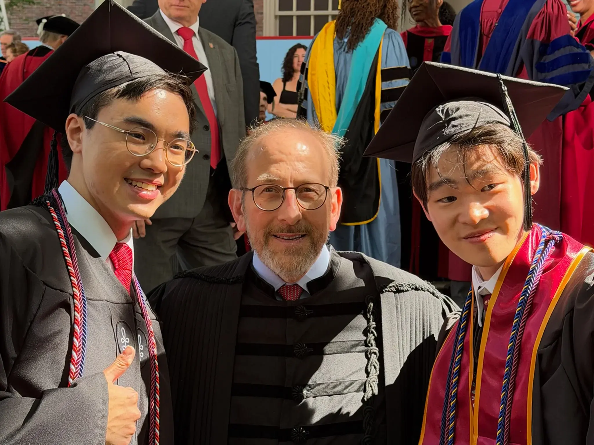 President Alan Garber with two graduates at Harvard Commencement