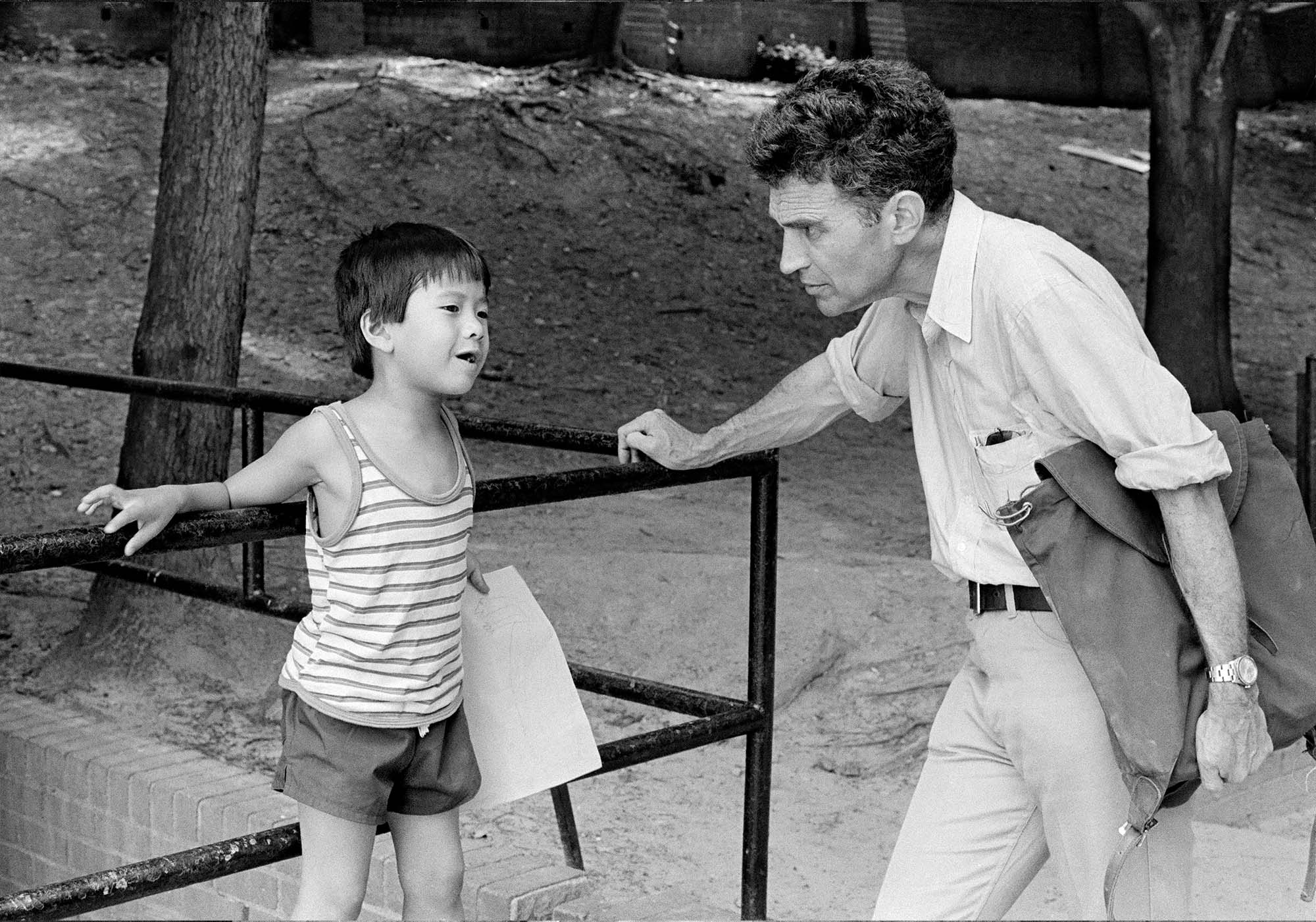 Black-and-white photos of a man interacting with a young child outdoors.