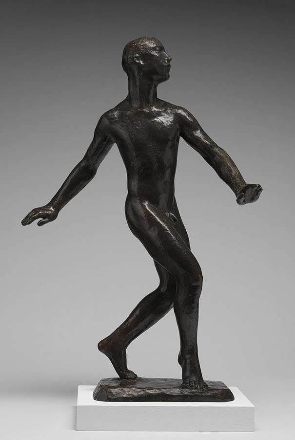 Bronze statue of a nude male figure mid-step, arms extended, head turned to the side.