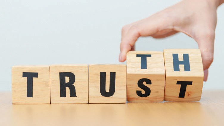 Wooden blocks with the letters TRUTH with a hand flipping the last two blocks to TH spelling out TRUTH