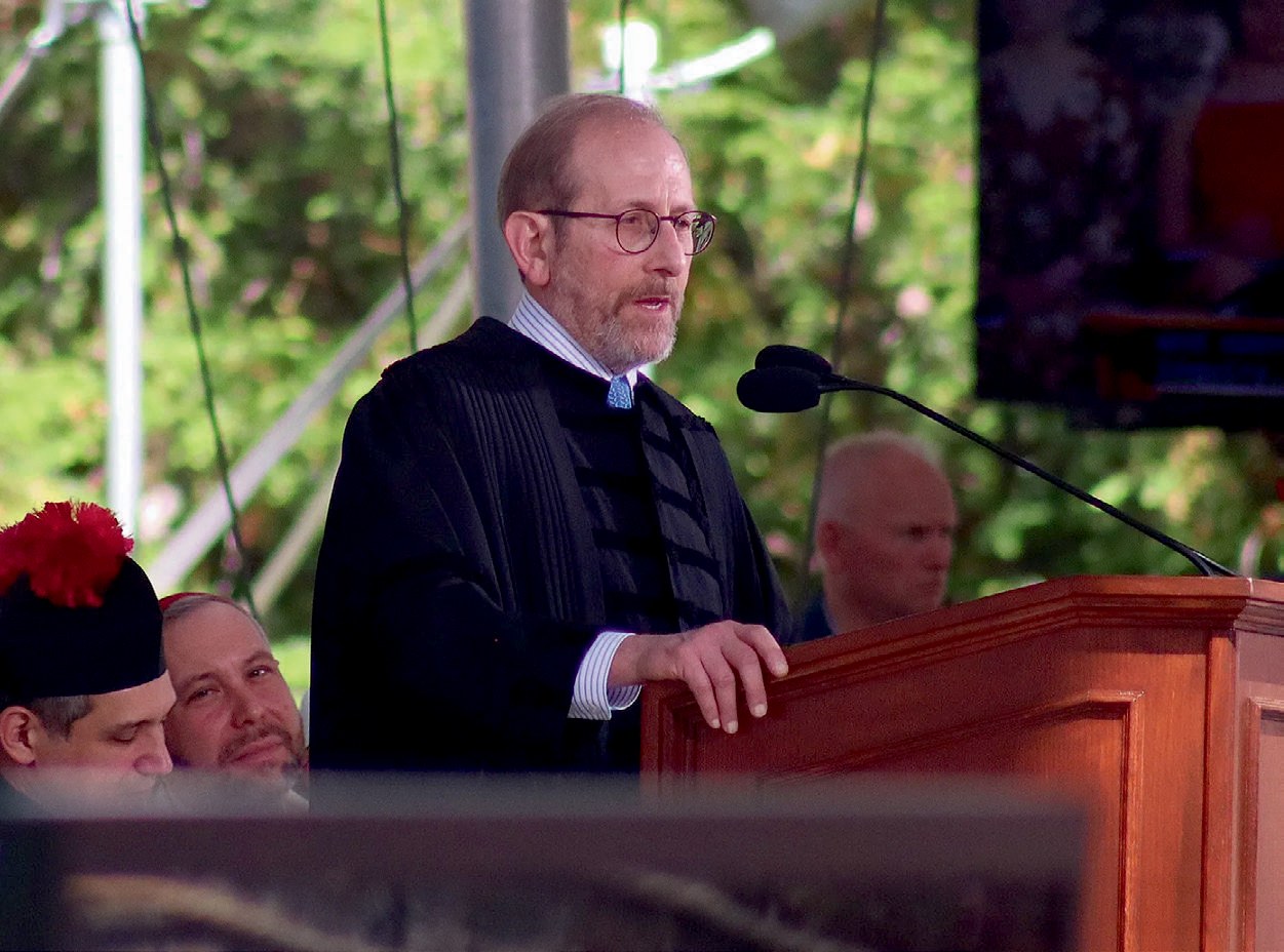 Alan Garber in black robe speaks at the podium 
