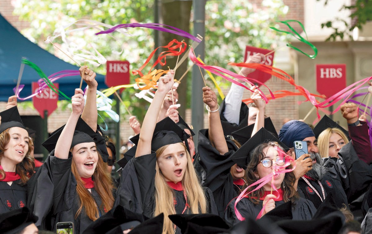 Graduates wave colorful streamers and celebrate during commencement festivities.