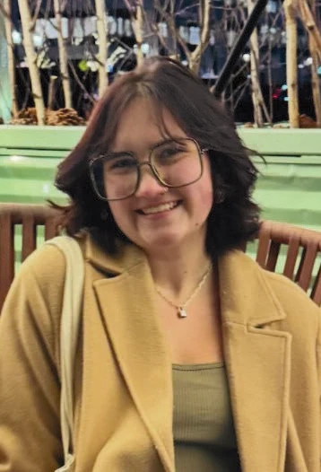 A woman wearing glasses smiling